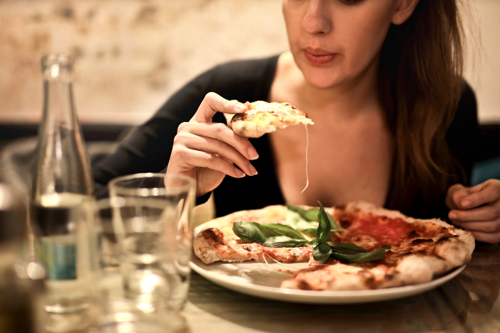 Woman blowing on fresh pizza